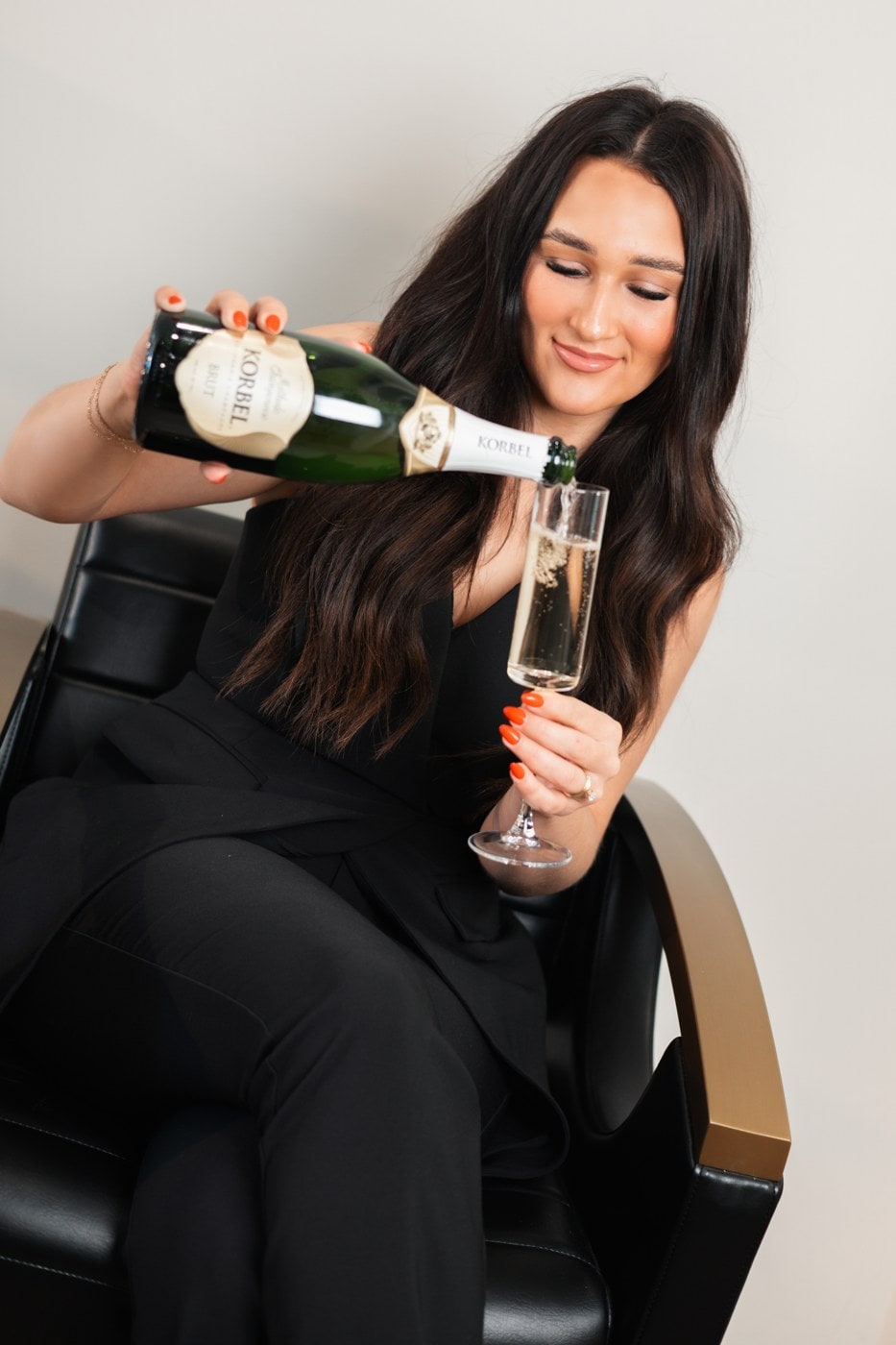 Stylist pouring champagne at the chair — LŪK House of Beauty, Norman OK