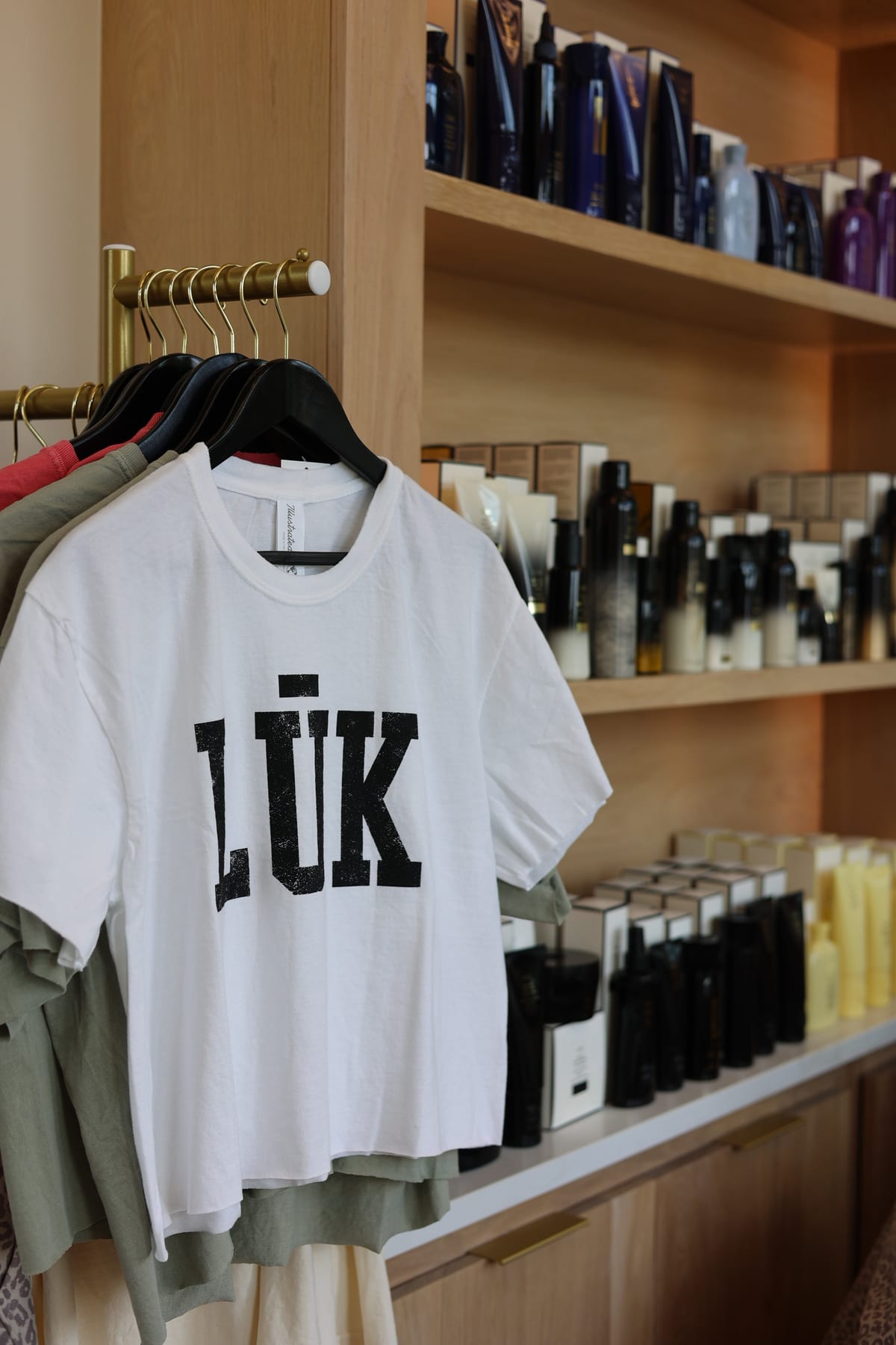 A white LŪK t-shirt hanging on the retail rail