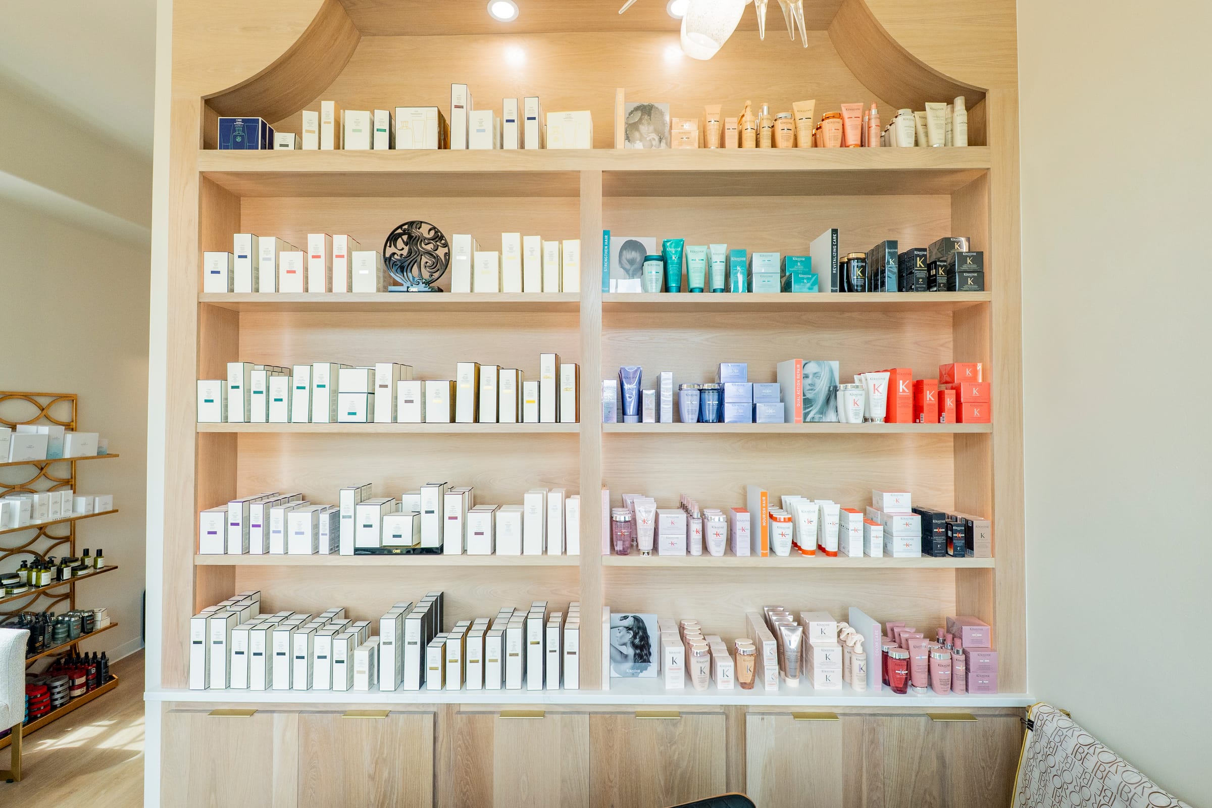 The retail wall floor to ceiling — Oribe and Kérastase arranged by color